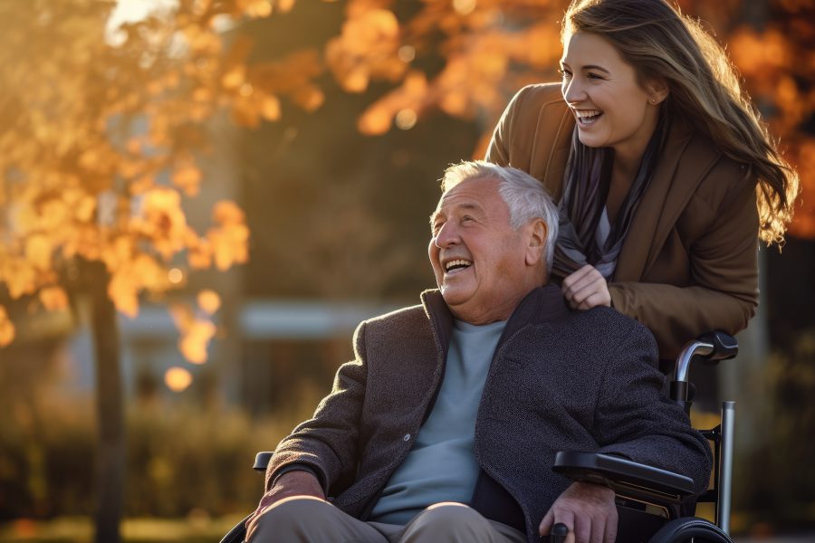 Senior man in wheelchair with his daughter in autumn park